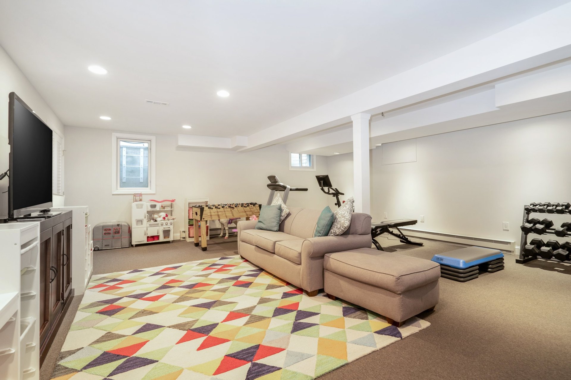Finished lower level with lounge, play area, and home gym