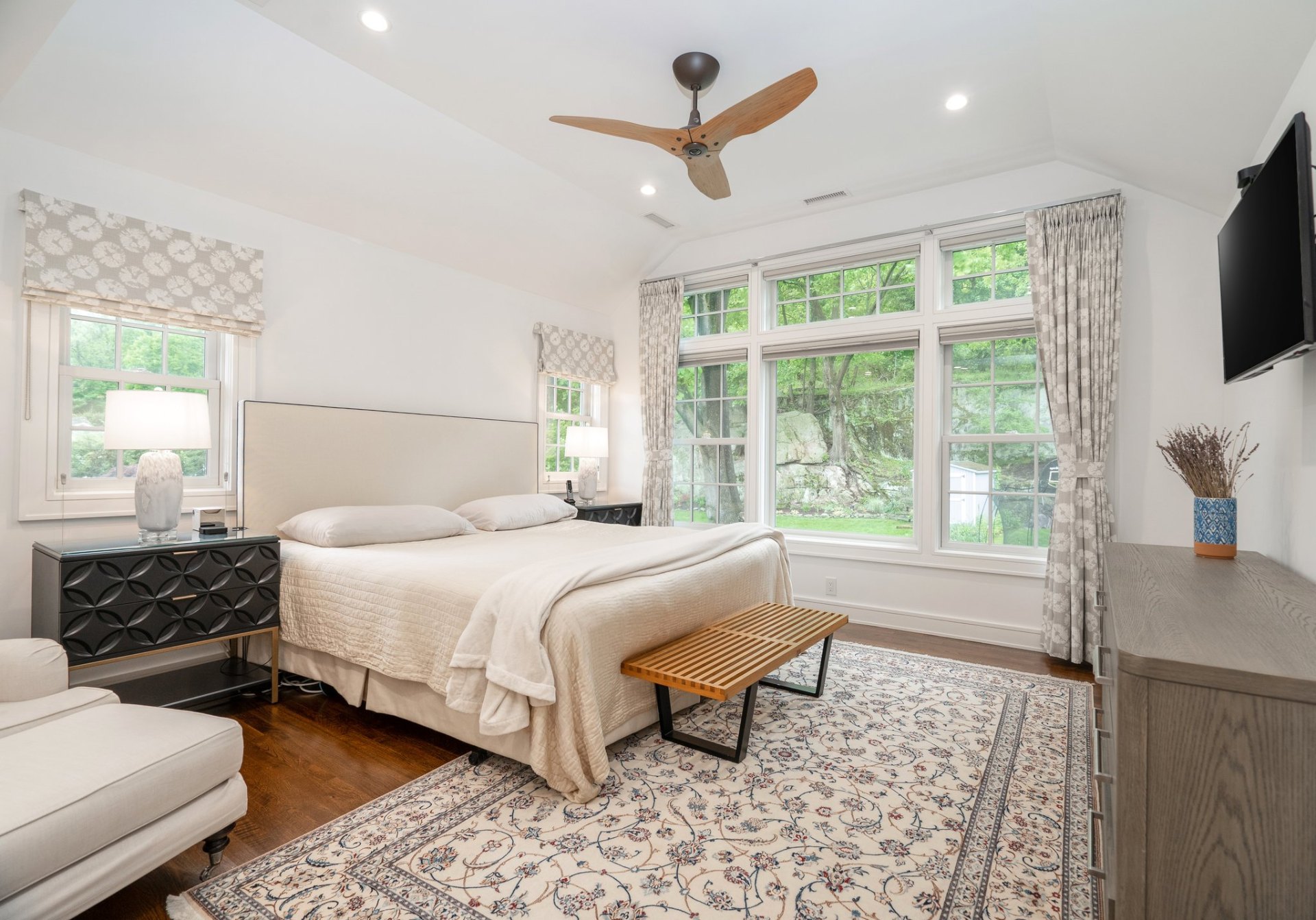 Serene primary bedroom with treetop views